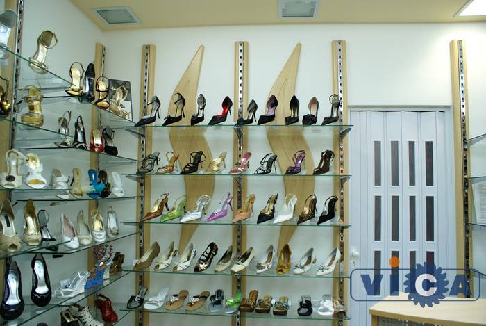 Обувное торговое оборудование дополнено фасонным изогнутым декором из МДФ в цвет настенных стоек.